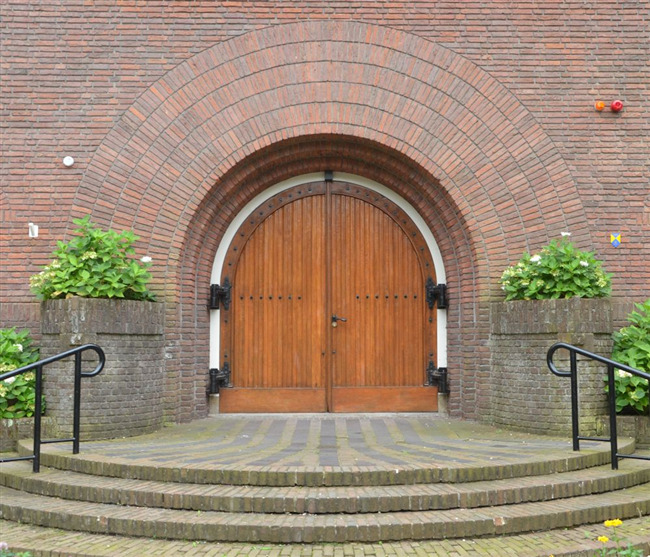 De ingang van de voormalige kerk, met een grote meervoudige metselboog
              <br/>
              Richard Keijzer, 2014-09-06